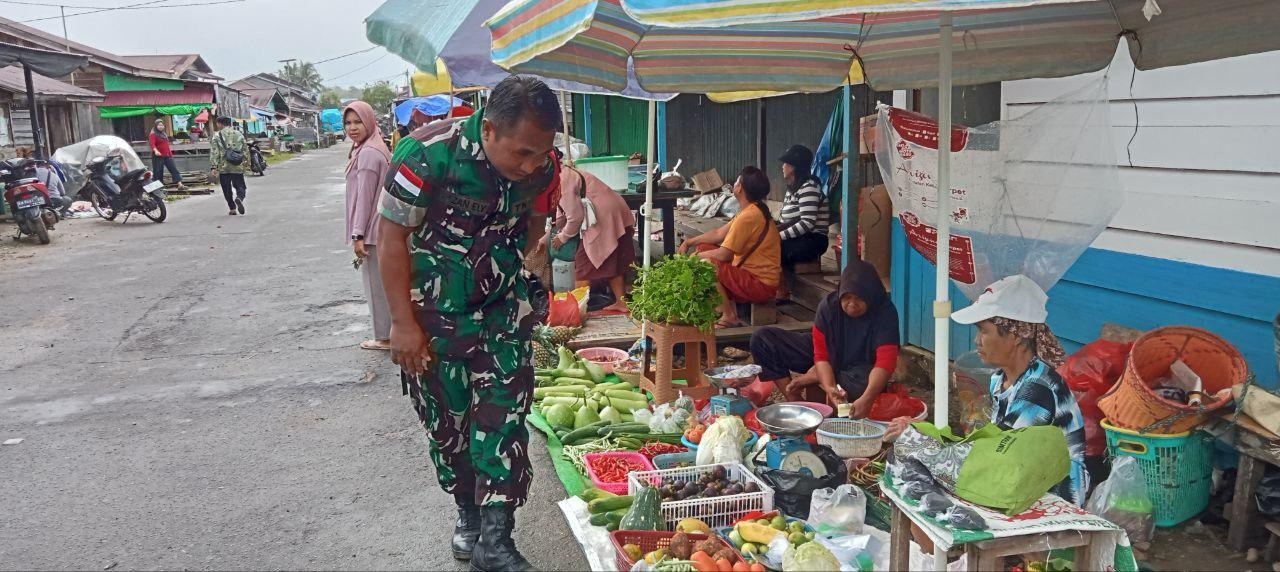 KOMUNIKASI : Babinsa Koramil Batang Lupar jajaran Kodim 1206/Putussibau melaksanakan kegiatan komunikasi sosial sekaligus pengecekan harga kebutuhan bahan pokok di Pasar Lanjak.