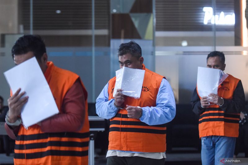 DIPERIKSA: Tiga tersangka kasus dugaan suap pemeriksaan pajak di lingkungan Kantor Pelayanan Pajak Madya Jakarta Utara menutupi wajahnya usai menjalani pemeriksaan di Gedung Merah Putih KPK, Jakarta,