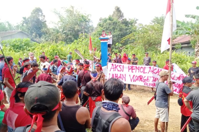 PROTES: Warga Dusun Nibung, Bengkayang membentangkan spanduk penolakan rencana kawasan transmigrasi.
