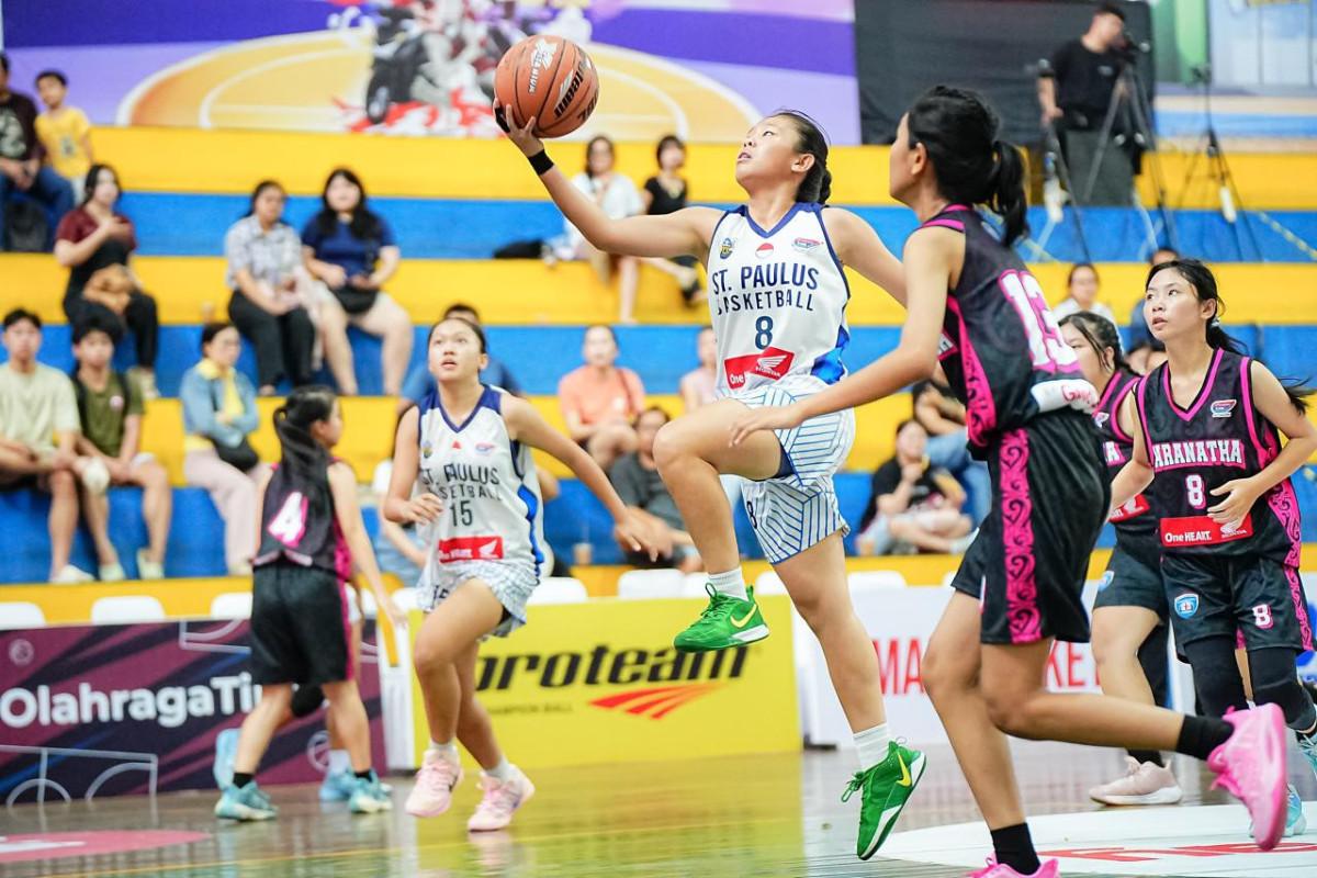 Vieny Gwenogia Theryatmadja (jersey putih) pemain tim basket putri SMA Santo Paulus Pontianak beraksi di Honda DBL with Kopi Good Day 2025&ndash;2026 West Kalimantan.