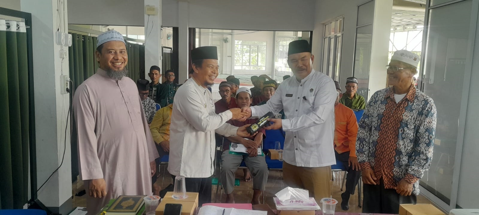CENDERA MATA: Kepala Kemenag Sambas menerima cendera mata dari Ketua YSRM setelah menjadi pemateri dalam kegiatan workshop penguatan pengelolaan wakaf.