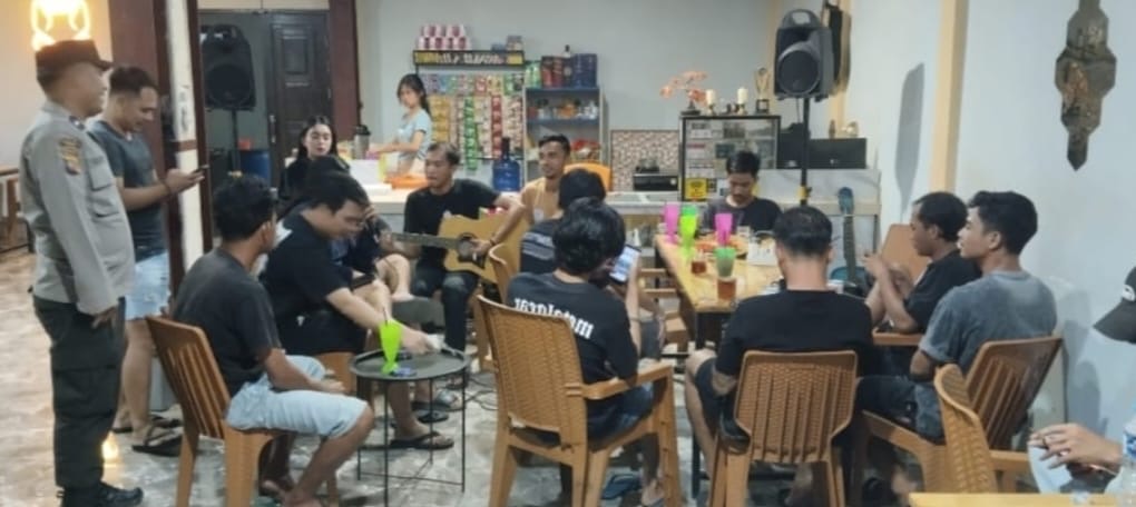 Patroli dialogis malam hari, polisi duduk santai bersama warga sambil ngopi demi menjaga kamtibmas tetap kondusif.