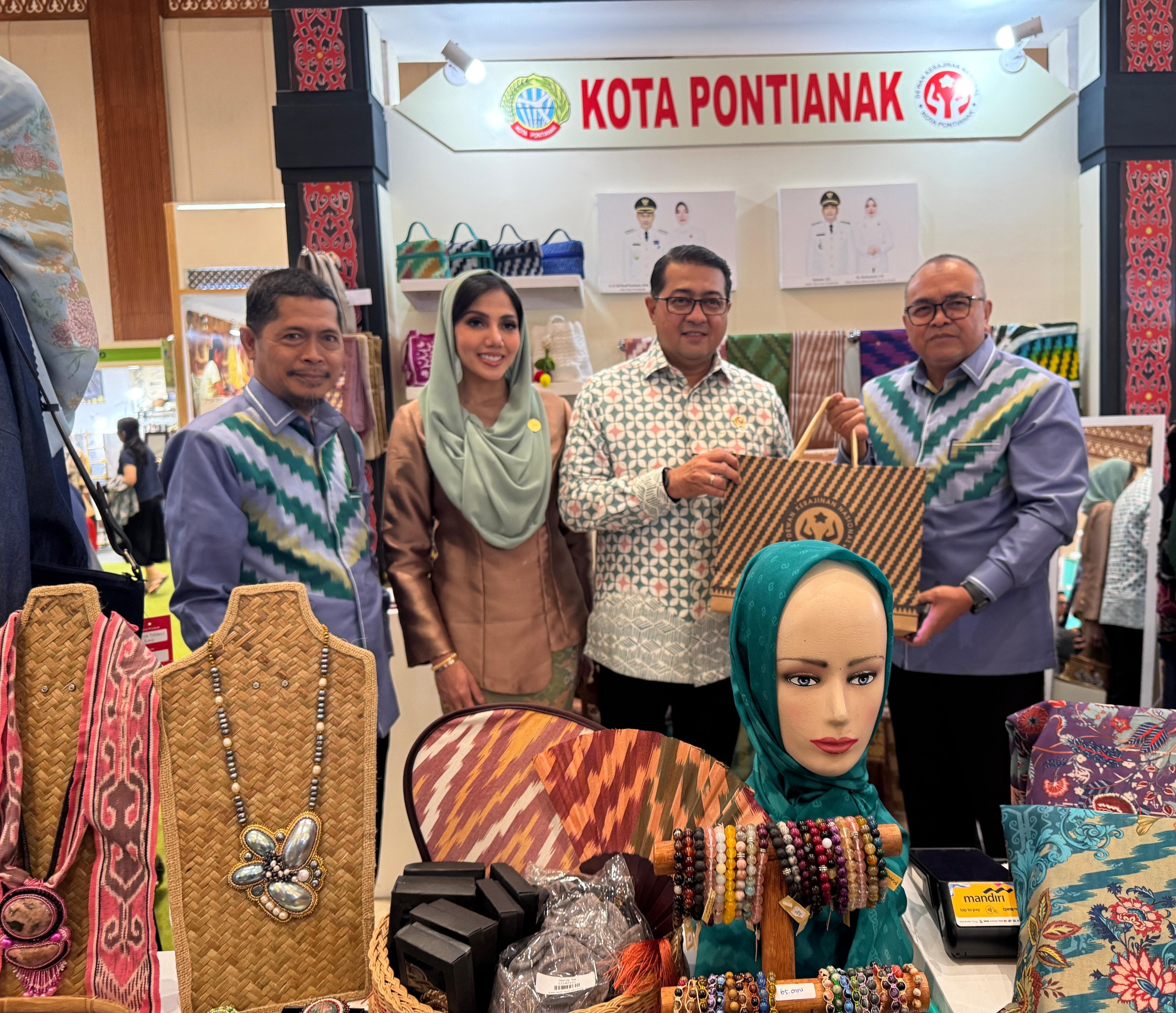 CENDERAMATA: Asisten Administrasi Umum Setda Kota Pontianak, Yusnaldi menyerahkan cenderamata kepada Menteri Ekonomi Kreatif Teuku Riefky Harsya saat mengunjungi stan Kota Pontianak.
