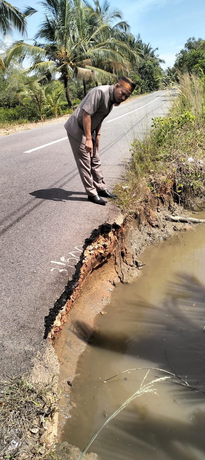AMBROL : Anggota DPRD KKU Dapil 1 Sukadana, Kamiriluddin saat melihat kondisi jalan Provinsi nyaris ambrol di Semanai, Desa Simpang Tiga, Kecamatan Sukadana, Kabupaten Kayong Utara.
