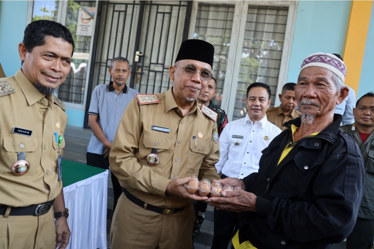 Sekda Kota Pontianak Amirullah secara simbolis menyerahkan telur kepada masyarakat dalam operasi pasar. 