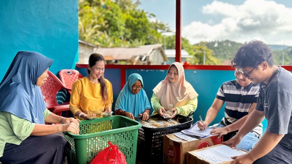 Warga Dusun Kelawar, Desa Pelapis, menyiapkan produk UMKM ke posko CSR untuk dipasarkanl ke Pulau Penebang, Kamis (26/2/2026). Jajanan produksi ibu-ibu desa dipasarkan di  Industri Pulau Penebang.