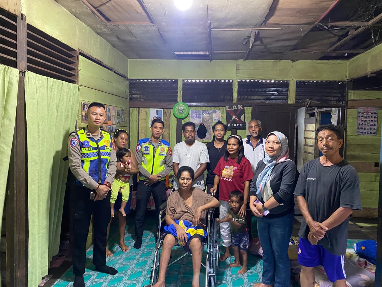 Satlantas Polres Sekadau menyerahkan kursi roda bagi Yasina, penderita stroke, melalui program Jumat Berkah, didampingi keluarga dan warga sekitar.