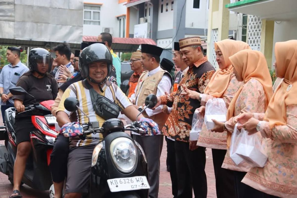 Warga antusias menerima pembagian takjil ramadan di Halaman Kantor Wilayah Kanwil Kemenag Kalbar, Kamis (5/3). 