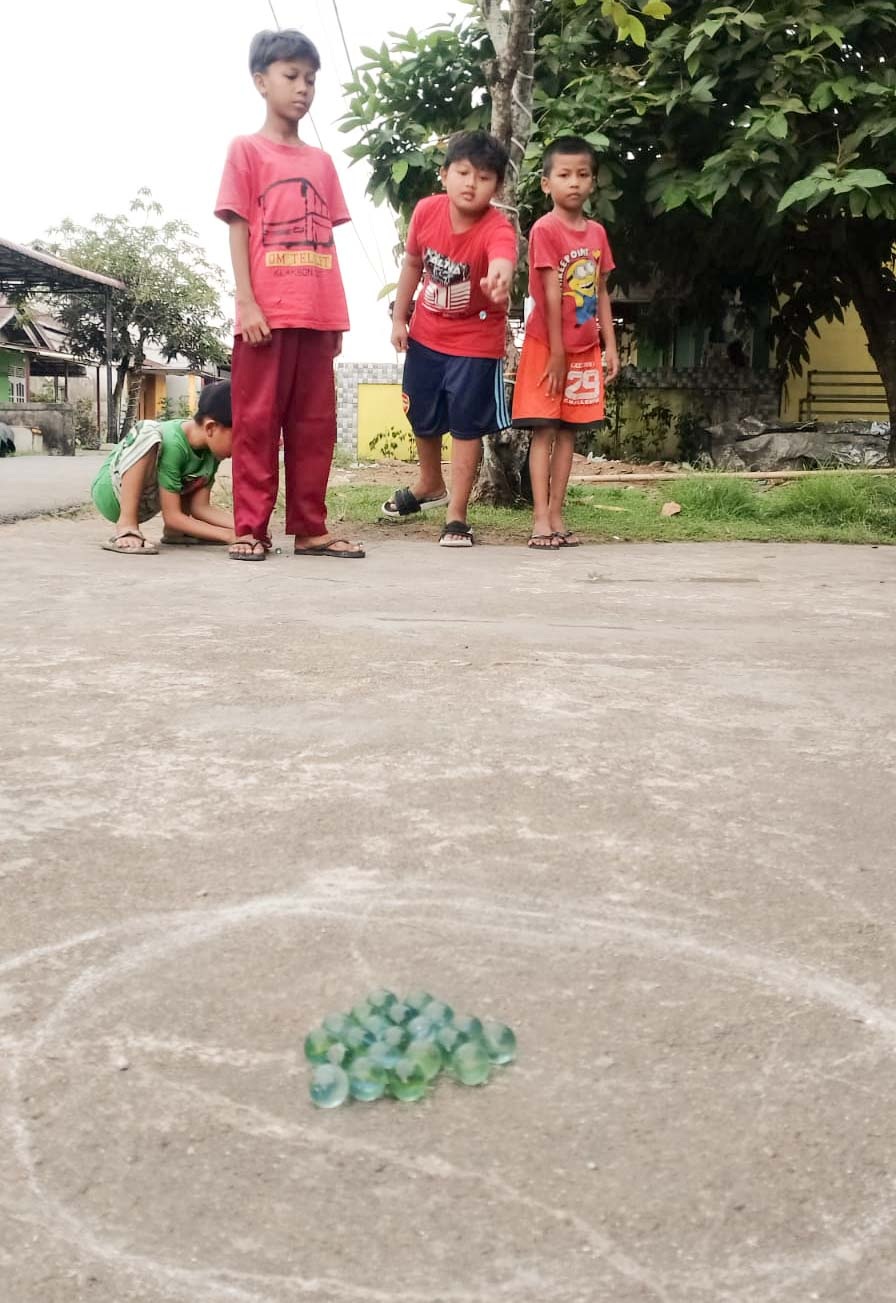 BERMAIN KELERENG: Anak-anak di Desa Kuala Dua,Kubu Raya bermain kelereng sambil menunggu waktu berbuka puasa. 