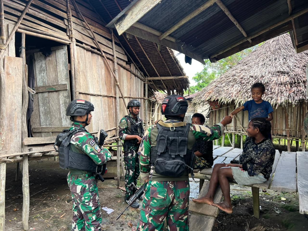 Prajurit Tentara Nasional Indonesia (TNI) dari Satgas Yon Parako 466 Pasgat berinteraksi dengan anak-anak saat patroli simpatik di permukiman warga Distrik Aboy, Kabupaten Pegunungan Bintang, 