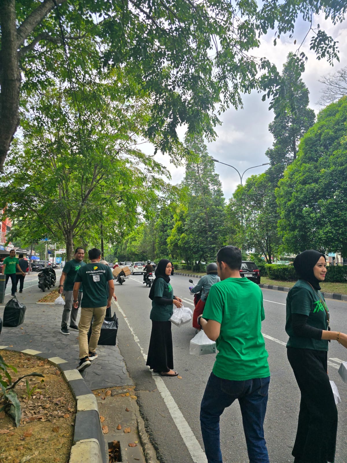 Karyawan PT Pegadaian Area Pontianak membagikan makanan siap saji kepada pengguna jalan dalam program sosial Mengetuk Pintu Langit di Pontianak, Senin (9/3).