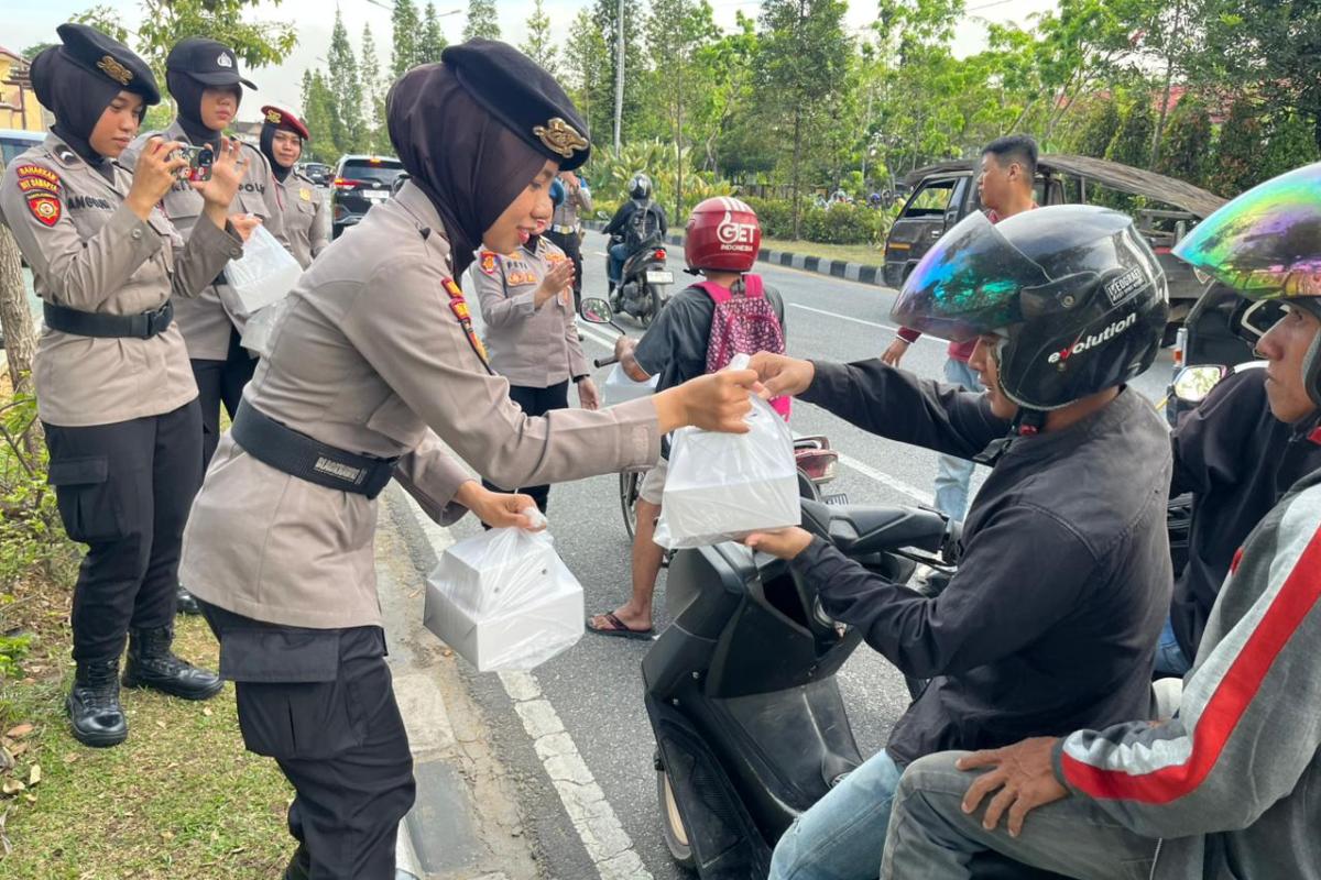 Personel Polwan Polda Kalbar berbagi takjil kepada masyarakat di depan Mapolda Kalbar, Senin (2/3).