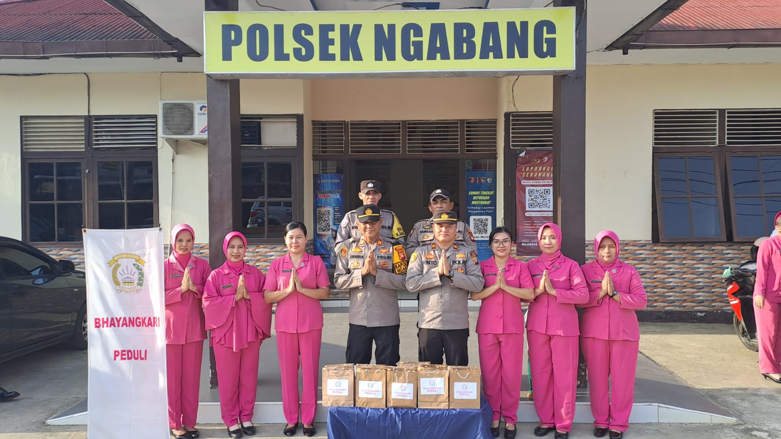 Kapolsek bersama personel Polsek Ngabang dan anggota Bhayangkari berfoto sebelum membagikan takjil kepada masyarakat dalam kegiatan bakti sosial Ramadan di depan Mapolsek Ngabang.