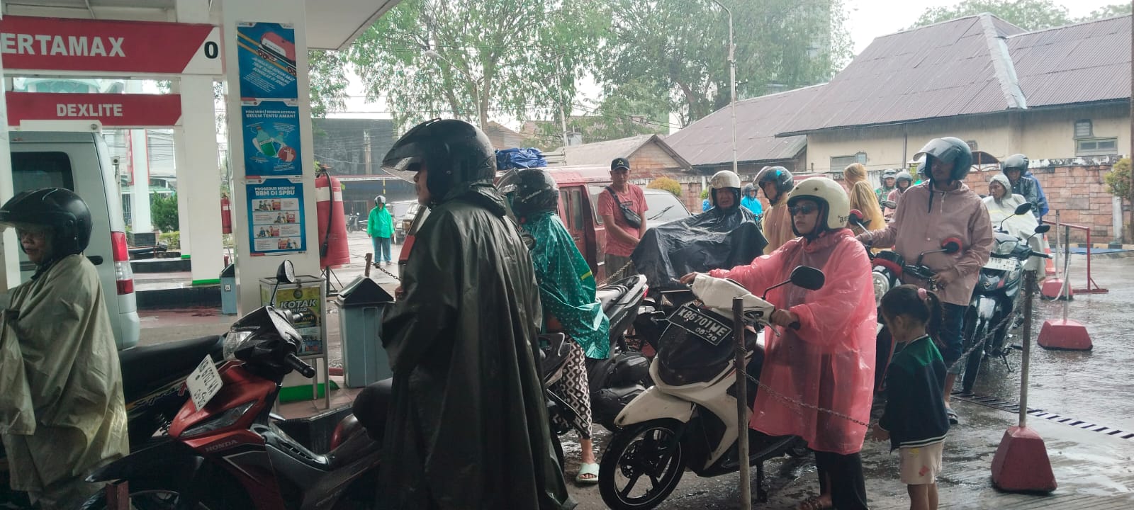 Meski diguyur hujan, warga tetap rela menunggu giliran untuk mengisi BBM di SPBU Jalan Merdeka, Selasa (10/3/2026).