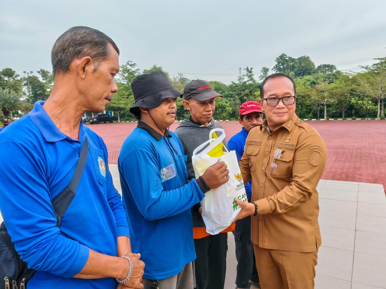 PAKET SEMBAKO: Bupati Kubu Raya Sujiwo menyerahkan paket sembako kepada petugas kebersihan di halaman Kantor Bupati Kubu Raya, Senin (9/3).