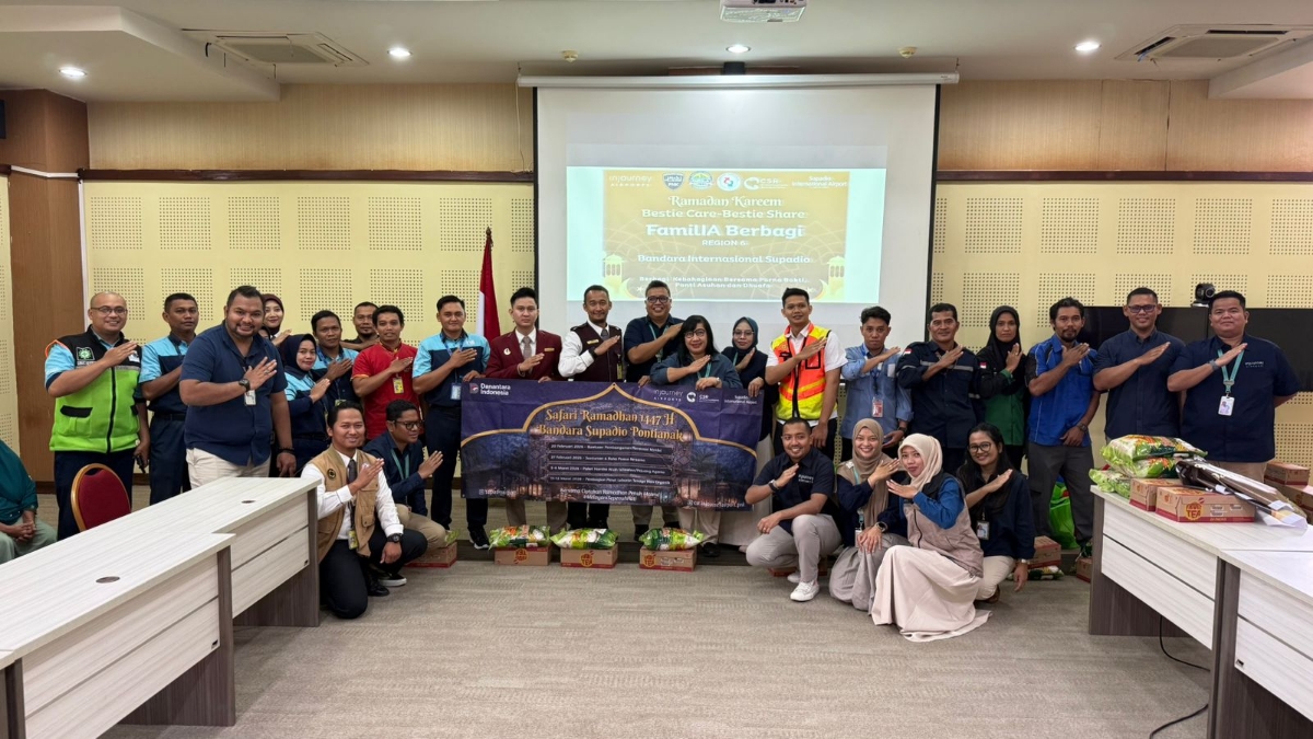 General Manager Bandara Internasional Supadio, Maya Damayanti (tengah depan) bersama jajaran berfoto bersama masyarakat penerima bantuan usai penyaluran ratusan paket sembako dalam Safari Ramadan. 