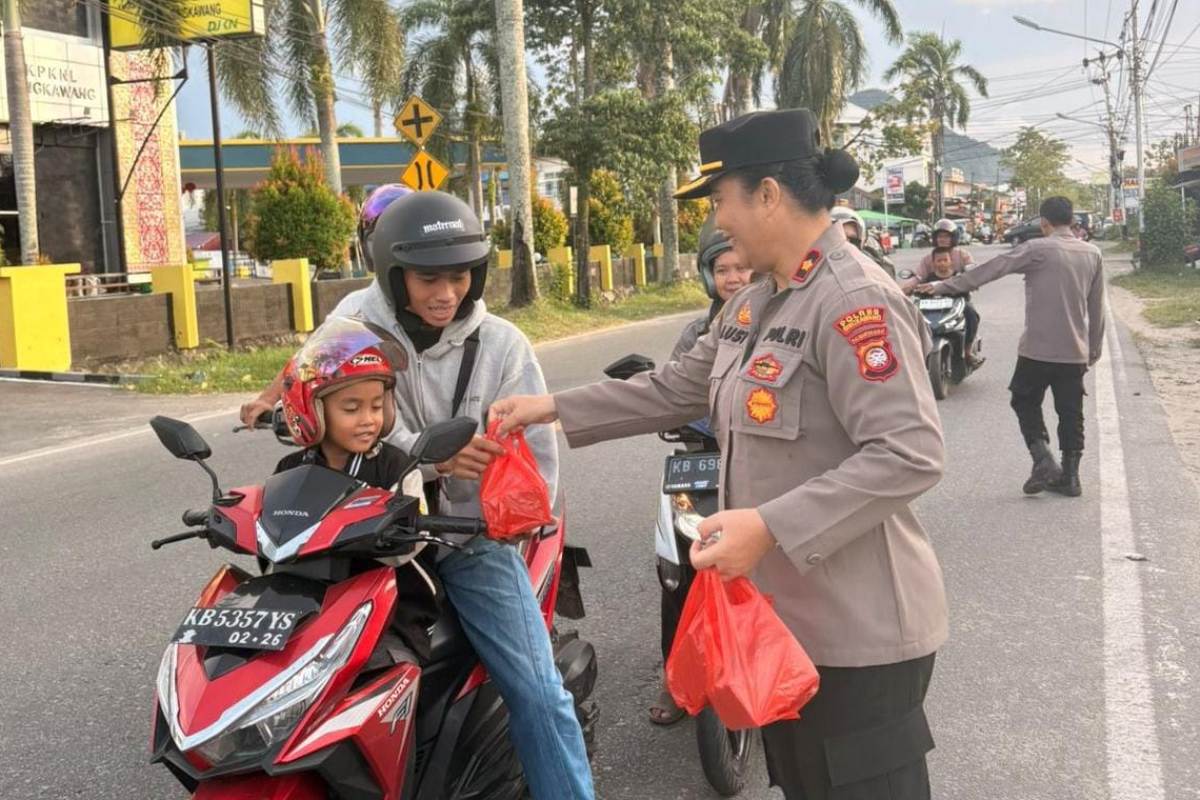 Personel Polsek Singkawang Barang membagikan takjil kepada masyarakat pada Selasa (3/3). 