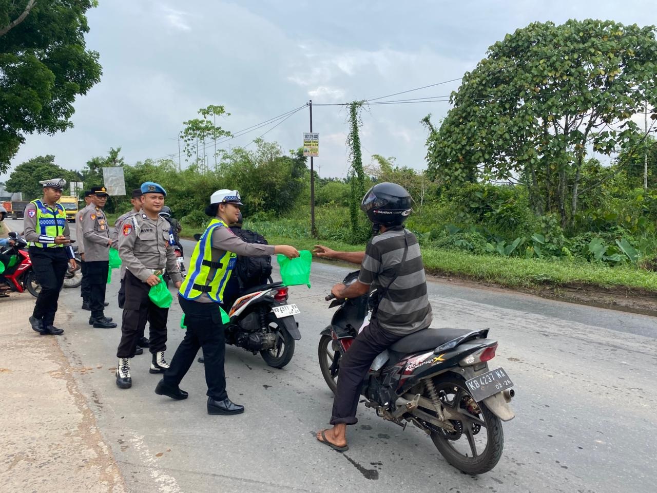BAGI: Jajaran Polres Kubu Raya membagikan puluhan paket takjil kepada pengendara.