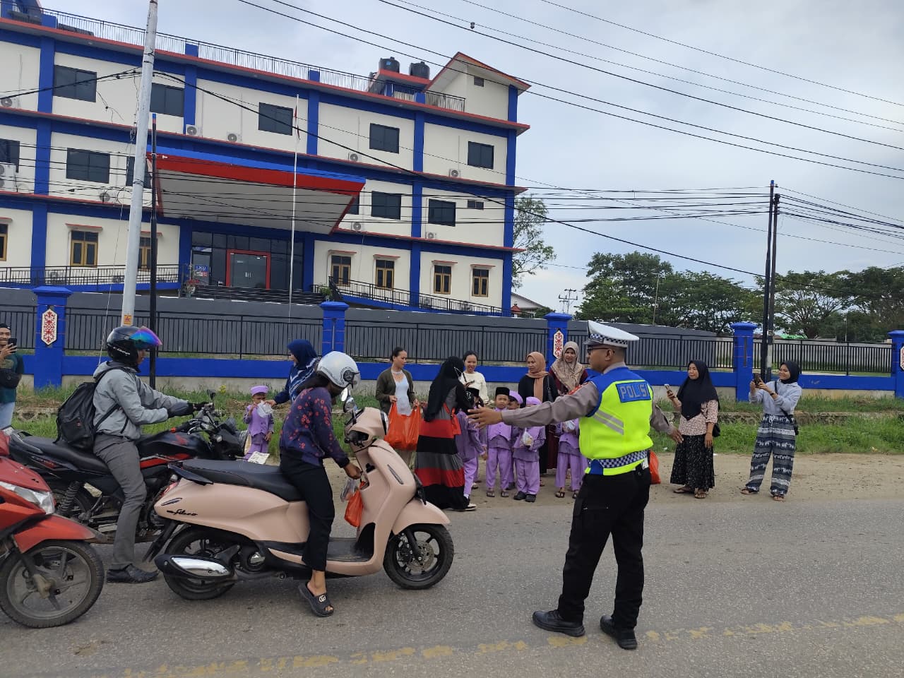 Polisi mengatur arus lalu lintas saat siswa TK dan mahasiswa Sekadau membagikan 200 takjil kepada pengendara.