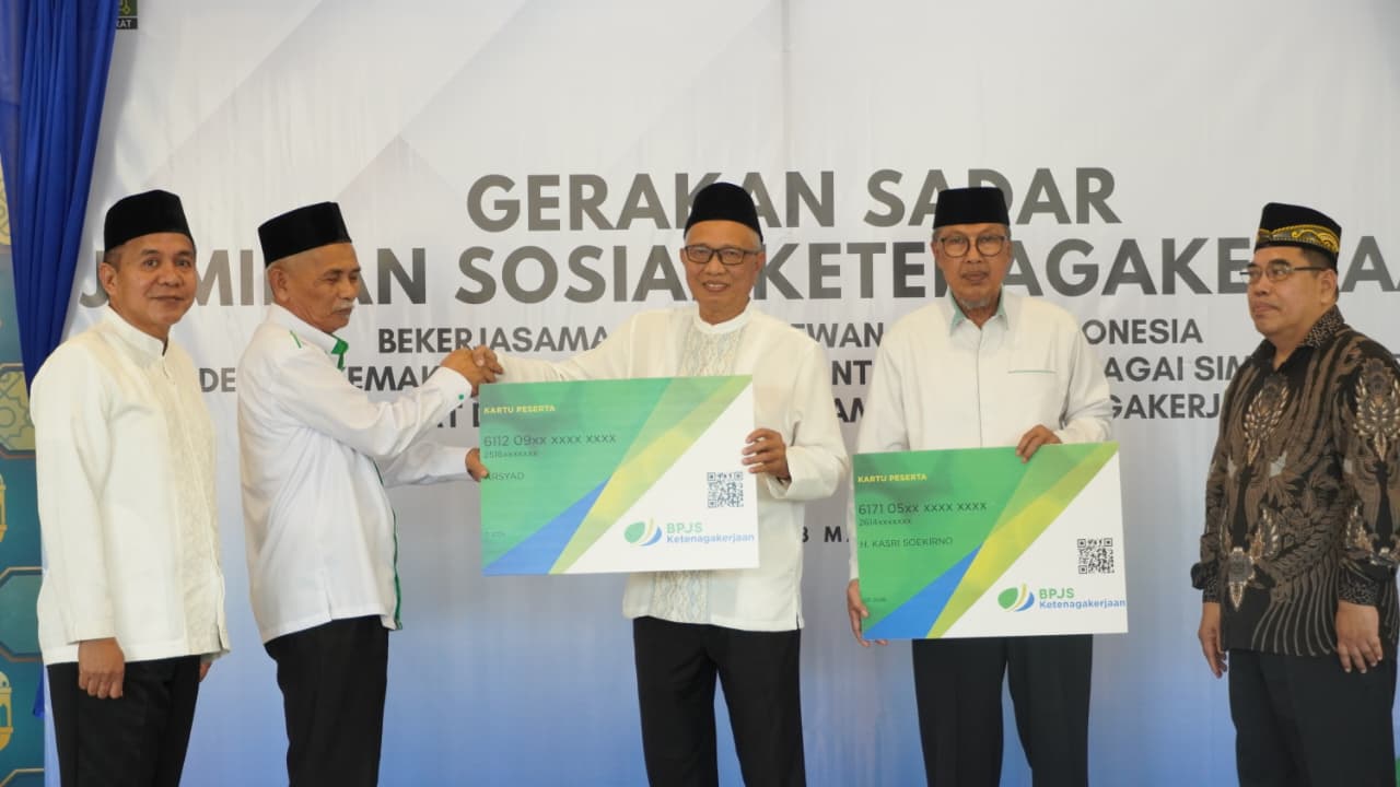 Penyerahan simbolis kartu kepesertaan BPJS Ketenagakerjaan kepada perwakilan peserta saat peluncuran Gerakan Sadar Jaminan Sosial Ketenagakerjaan yang berkolaborasi dengan Dewan Masjid Indonesia.