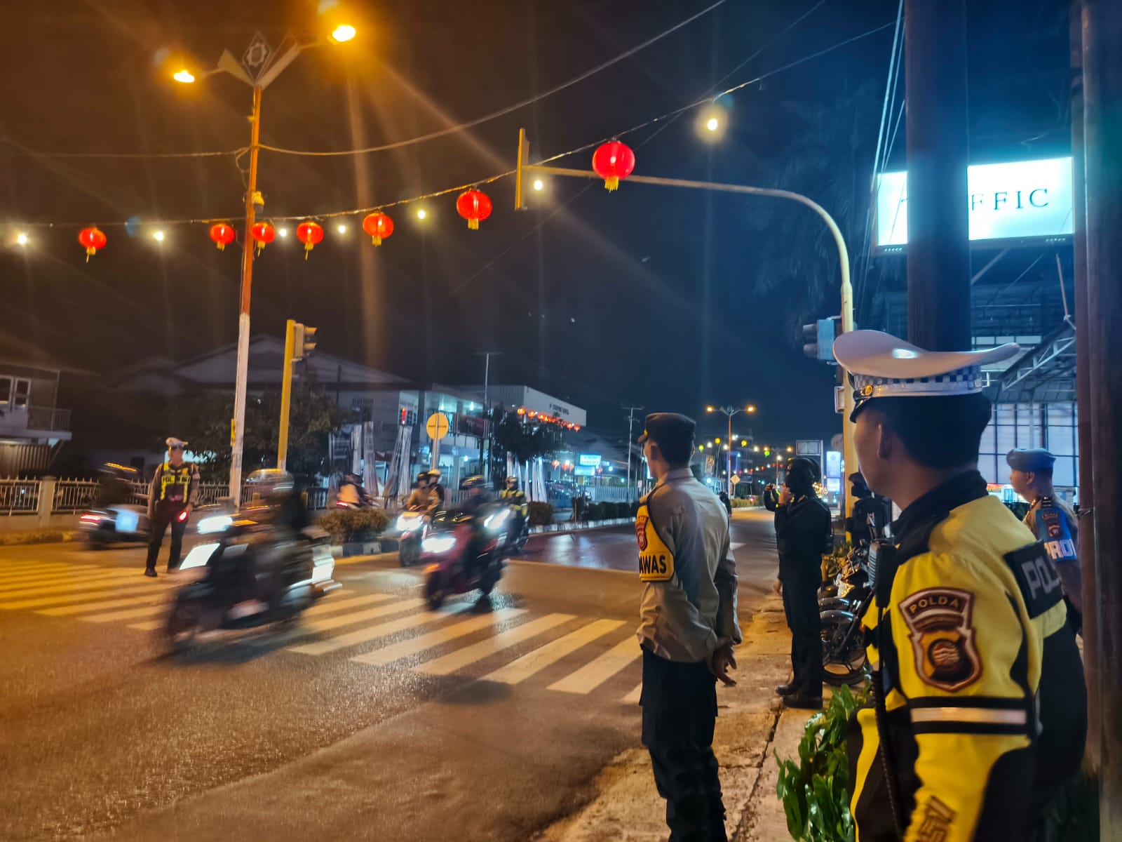 Petugas dari Polres Singkawang melakukan patroli malam di persimpangan jalan Kota Singkawang untuk memastikan situasi kamtibmas tetap aman dan kondusif.