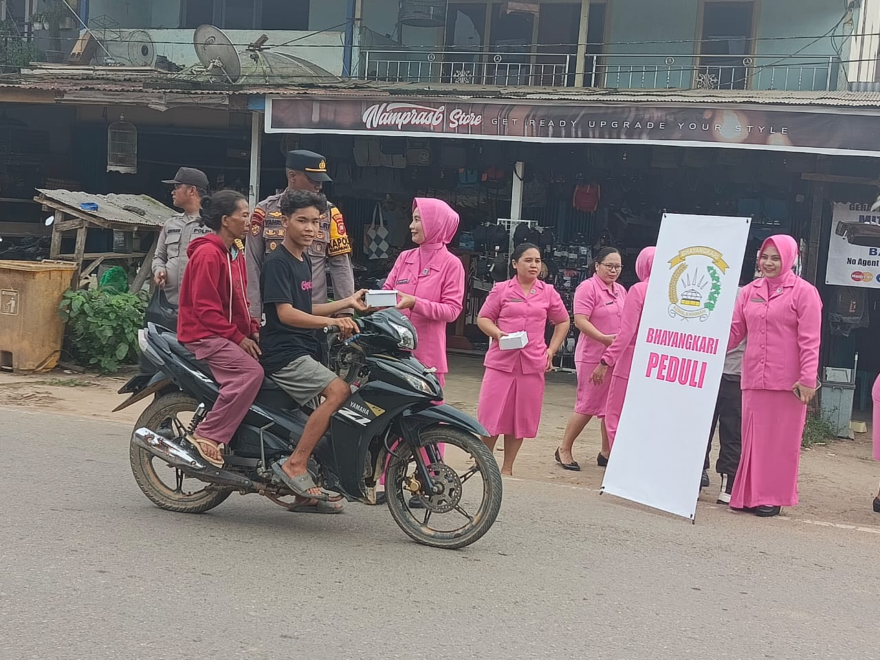 Bhayangkari Simpang Hulu membagikan takjil kepada masyarakat yang melintas, wujud kepedulian sosial di bulan Ramadhan.
