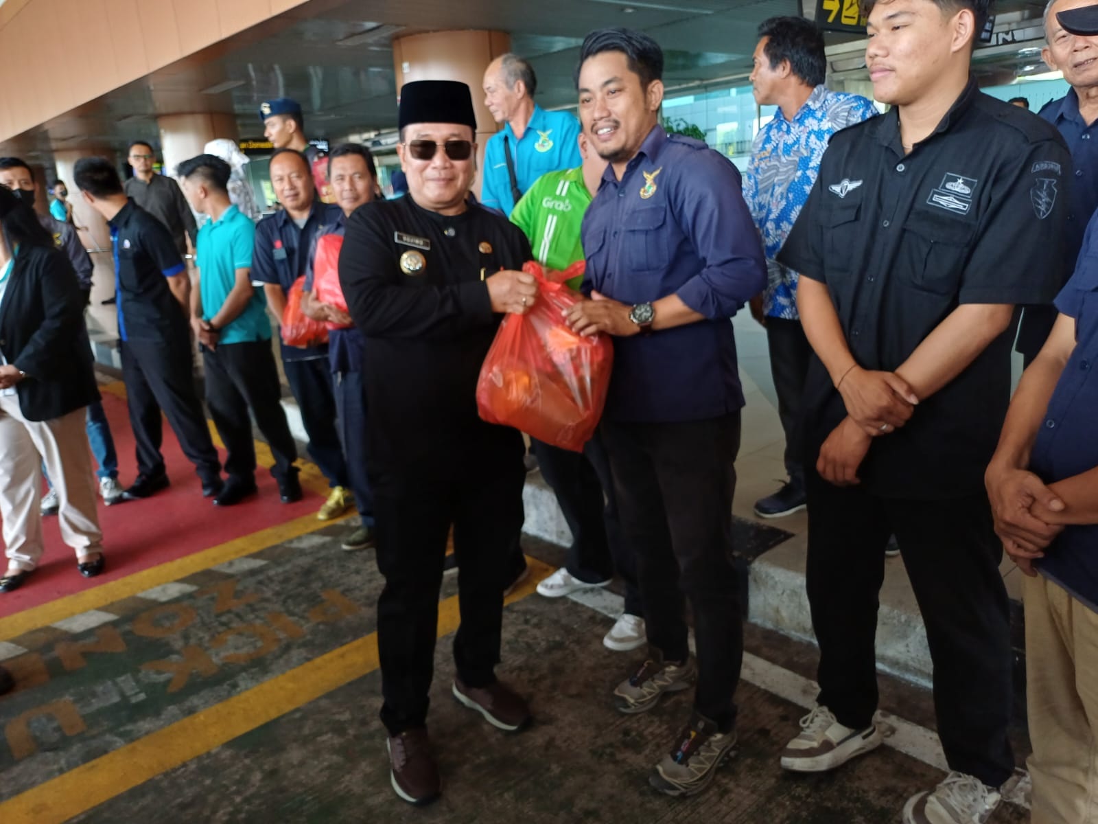 PAKET SEMBAKO: Bupati Kubu Raya Sujiwo menyerahkan secara simbolis bantuan paket kebutuhan pokok kepada pengemudi transportasi daring di kawasan Bandara Internasional Supadio, Jumat (13/3).