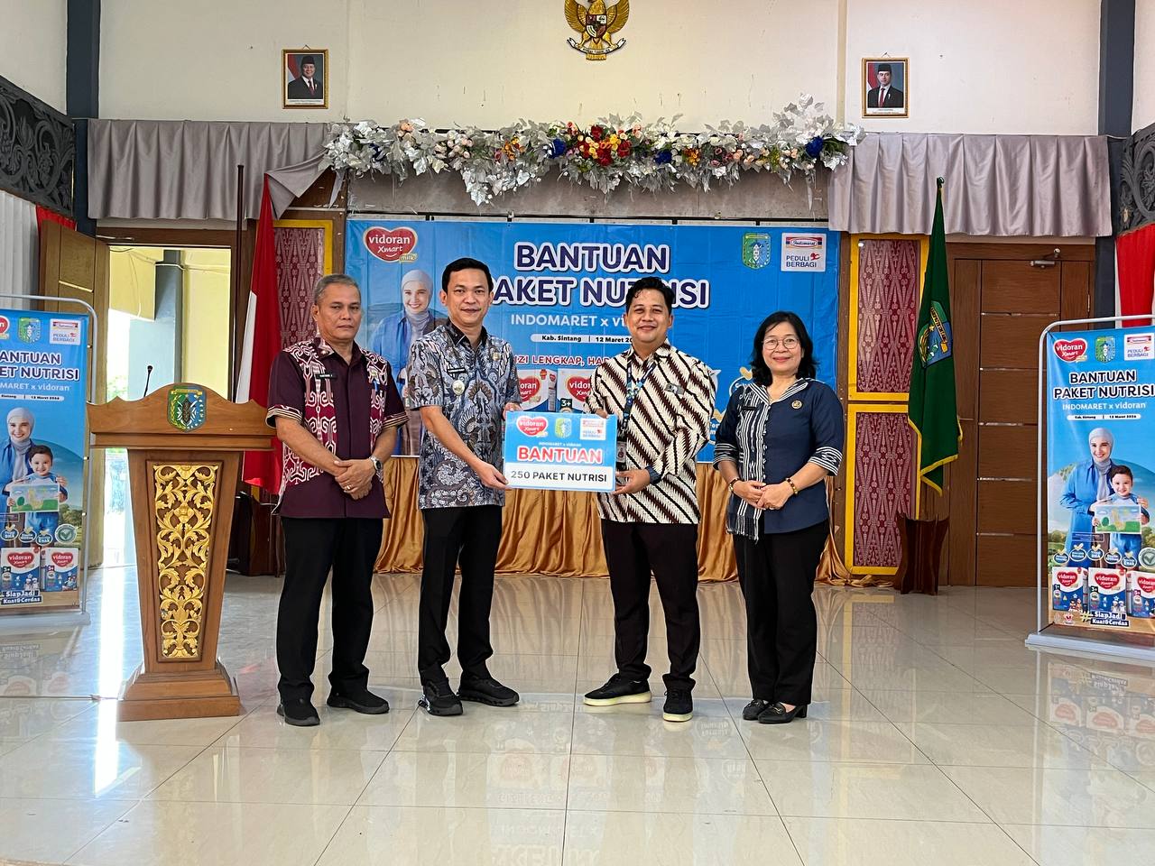 Branch Manager PT Indomarco Prismatama Cabang Pontianak, Bhineka Bayu Aji menyerahkan bantuan paket nutrisi yang diterima langsung oleh Wakil Bupati Sitang, Florensius Ronny dan didampingi Asisten 1