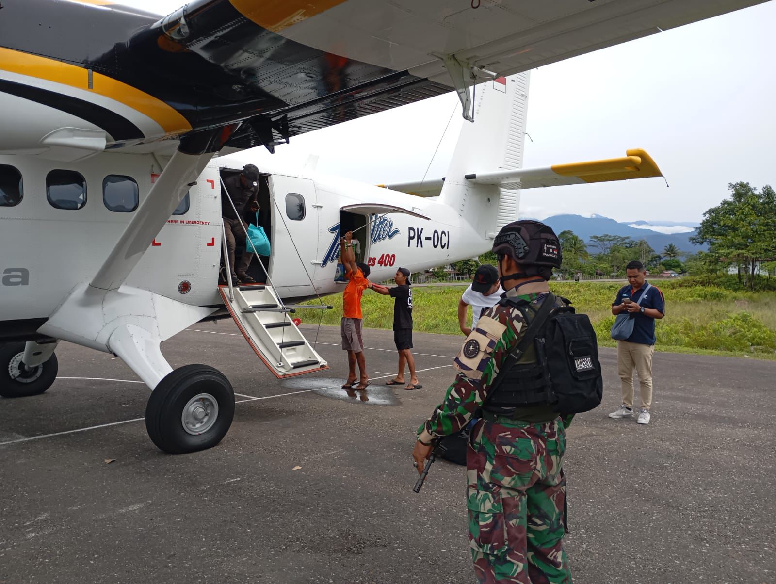 Personel Satgas Yon Parako 466 Pasgat mengamankan proses bongkar muat logistik dari pesawat perintis di Lapangan Terbang Kenyam, Kabupaten Nduga, Papua Pegunungan.