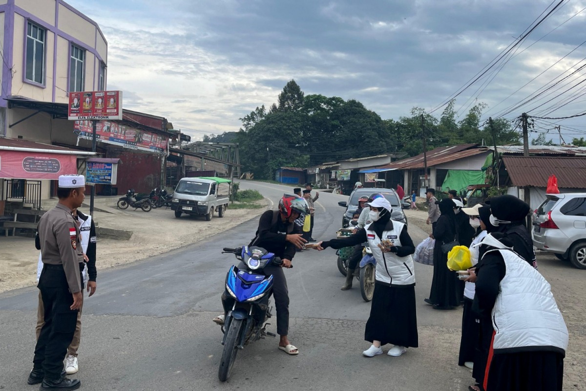 Personel Polsek Sekayam membagikan takjil bersama organisasi Paskas. 