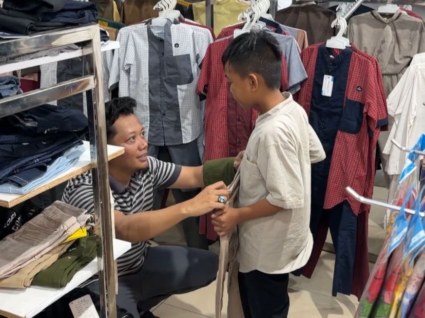 BELANJA : Ketua AJK, Theo Bernadhi, menemani langsung anak-anak berbelanja baju lebaran, Minggu (15/3).