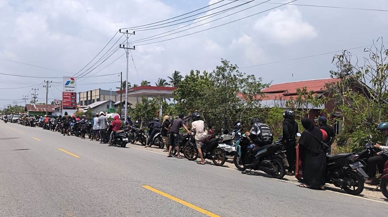 Antrean kendaraan di SPBU Desa Pasir meluber sampai ke pinggir jalan raya.