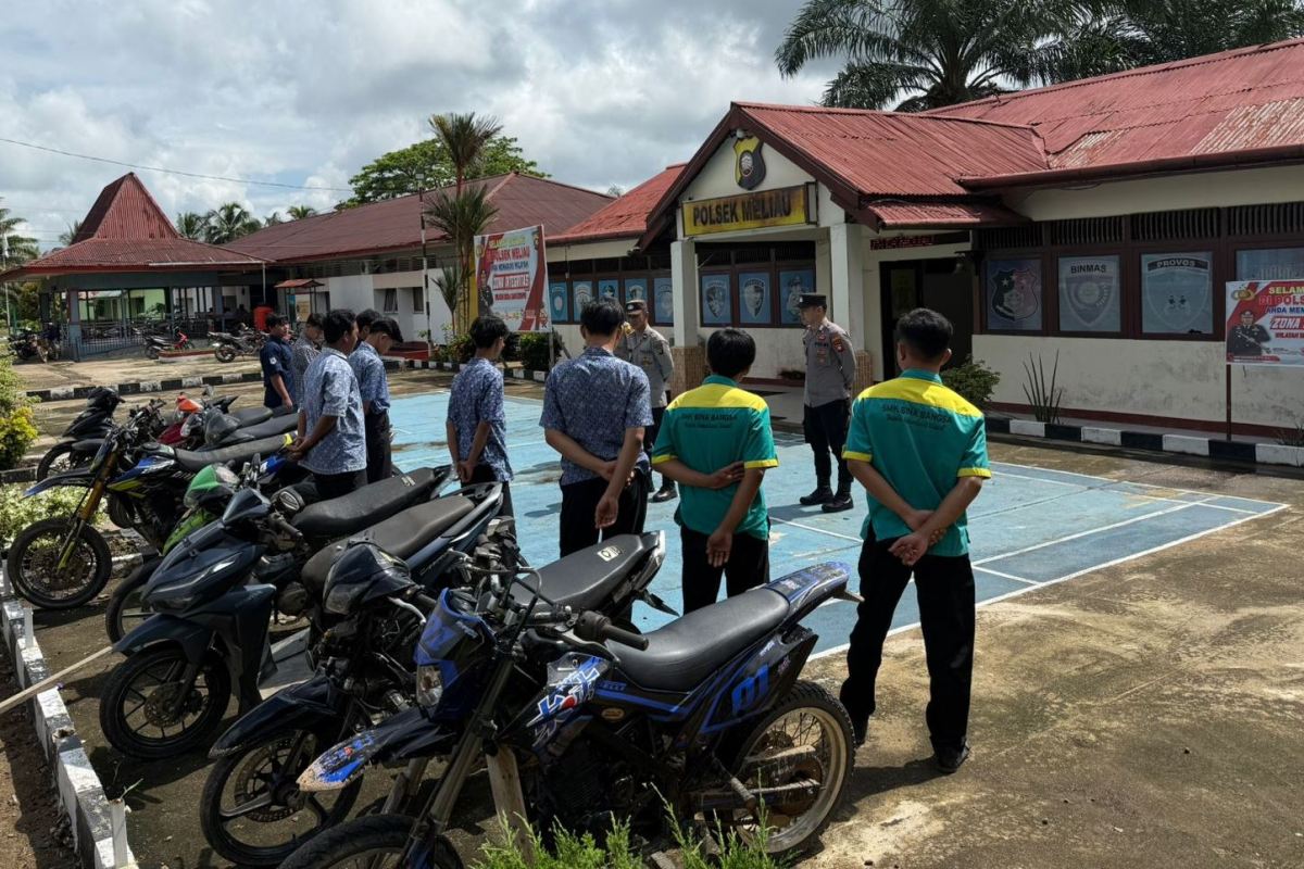 Personel Polsek Meliau menggelar razia knalpot brong di sekolah.