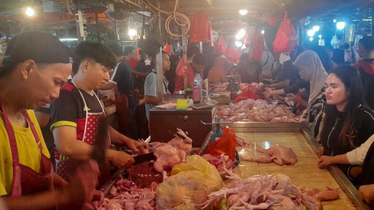 Pedagang melayani pembeli ayam potong di Pasar Flamboyan Pontianak pada Kamis (19/3). 