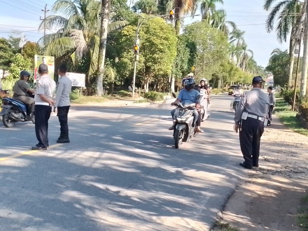 ATUR: Petugas Dishub-LH Mempawah mengatur arus lalu lintas di jalan raya.