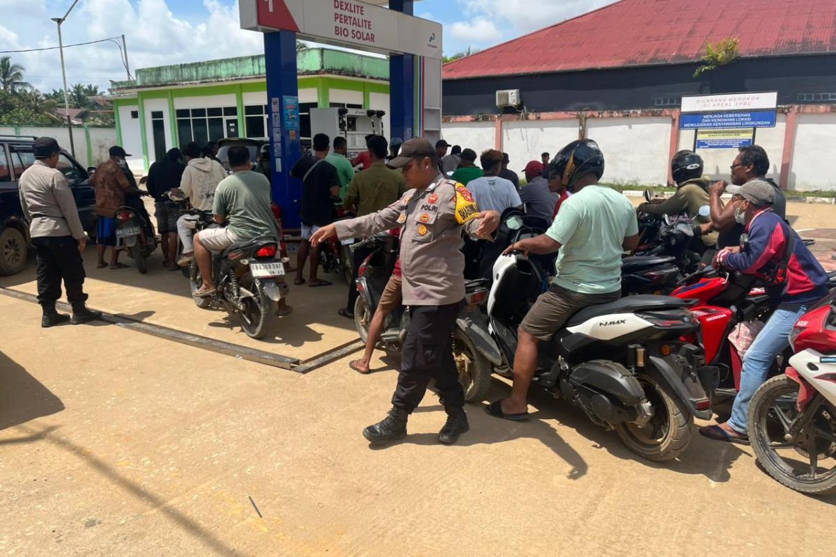 Personel Polsek Meliau mengamankan antrean BBM di wilayah tersebut pada Selasa (24/3). 