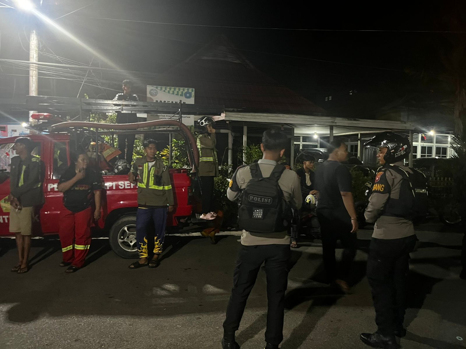 Petugas kepolisian dan tim pemadam kebakaran bersiaga di lokasi keributan di Jalan Tanjungpura, Pontianak, Selasa (24/3) malam.
