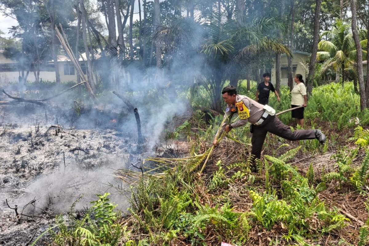 Personel Satuan Lalu Lintas Polres Melawi dan Polsek Nanga Pinoh memadamkan api di lahan milik Yayasa Emaus, Nanga Pinoh pada Rabu (25/3).
