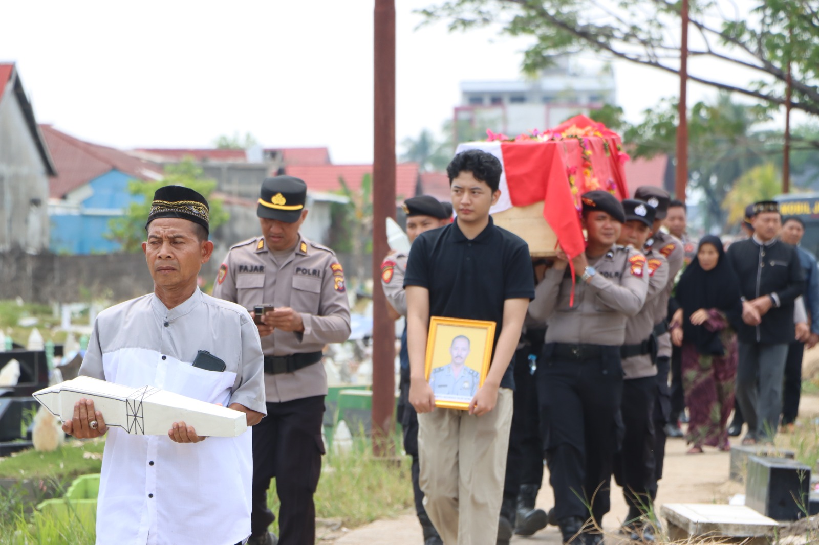 Prosesi pemakaman dan penghormatan terakhir anggota Polri, diiringi suasana duka dan doa dari keluarga serta rekan sejawat.