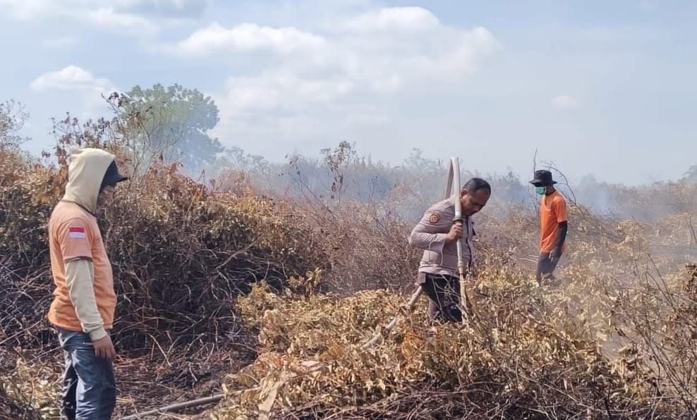 PADAMKAN API: Anggota polisi ikut memadamkan api di Matan Hilir Utara.