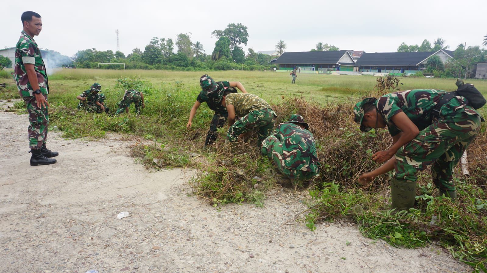 GOTONG-ROYONG: Pembersihan lokasi lapangan sepak bola Lawit yang terletak di Kelurahan Kedamin Hulu untuk persiapan penyambutan kedatangan Batalyon TP 927/UK di Kapuas Hulu. 