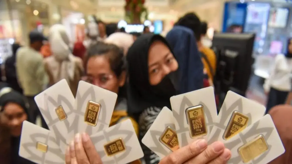 Pengunjung menunjukkan logam mulia Antam yang dibeli di Jakarta, Jumat (27/3). (ANTARA)