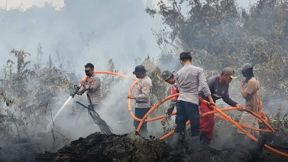 KARHUTLA: Polres Sambas bersama tim saat melakukan pemadaman kebakaran lahan. (ISTIMEWA)