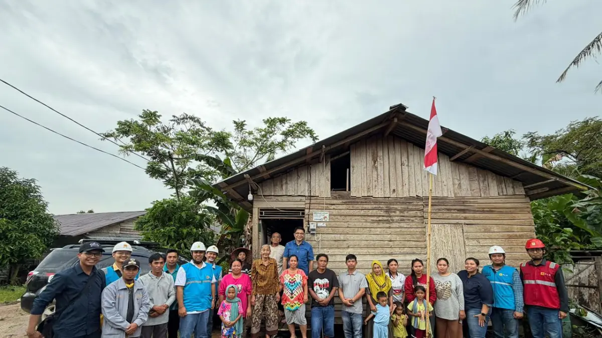 Warga bersama tim listrik desa berfoto di depan rumah di Desa Buduk Sempandang, Sambas, sebagai simbol percepatan pemerataan akses listrik di wilayah terpencil.