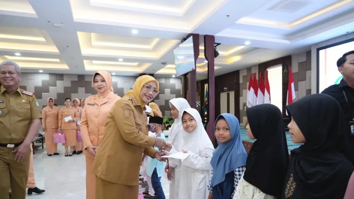SANTUNAN: Erlina memberikan santunan kepada anak yatim saat menghadiri Seminar Harmonisasi Kerukunan Umat yang digelar oleh Dharma Wanita Persatuan (DWP) Provinsi Kalimantan Barat.  (WAHYU ISMIR/PONTIANAK POST)
