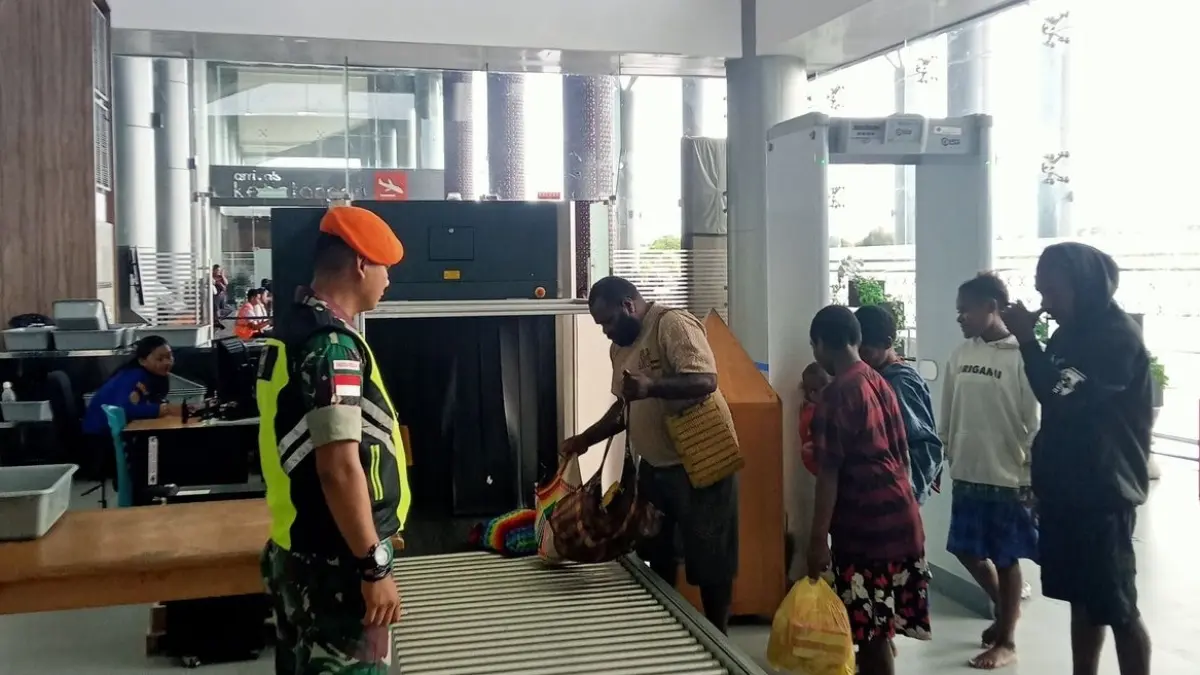 Personel TNI Korpasgat membantu penumpang saat pemeriksaan barang di Bandara Nabire dengan pendekatan humanis.