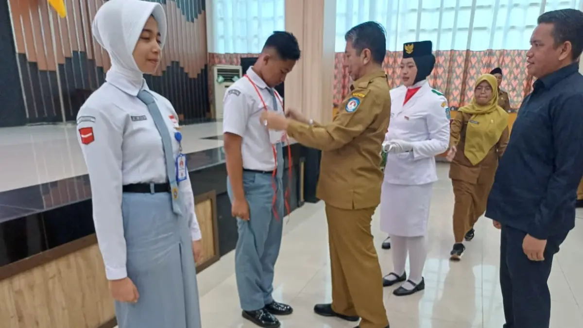 SIMBOLIS: Kepala Kesbangpol Kubu Raya, Amini Maros secara simbolis memasangkan tanda peserta bagi perwakilan peserta seleksi Calon Paskibraka Kubu Rata tahun 2026. (Ashri Isnaini/Pontianak Post)
