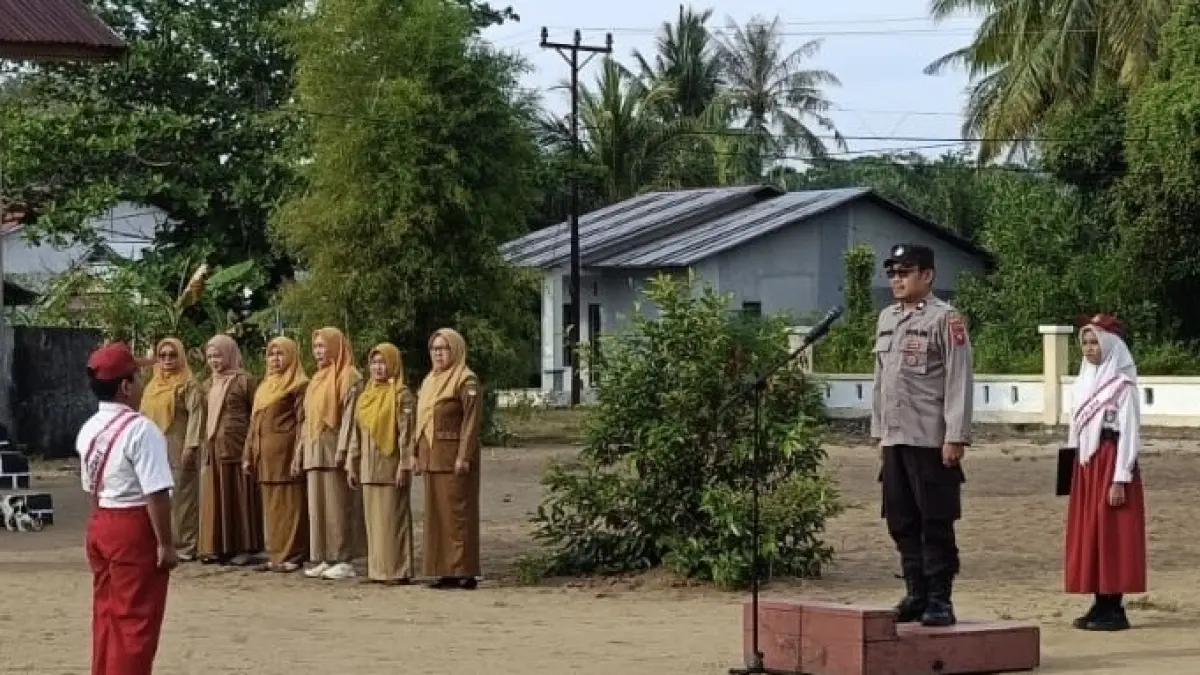 Anggota Polsek Muara Pawan memimpin upacara di salah satu sekolab dasar di Muara Pawan. (ISTIMEWA)