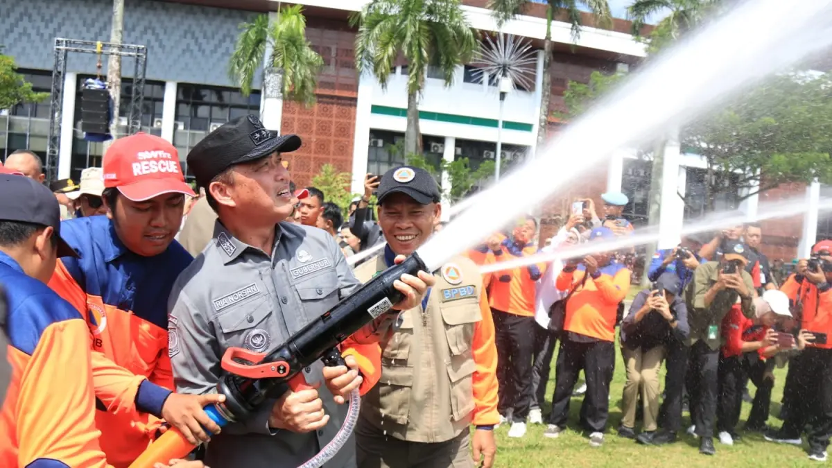 Gubernur Kalbar Ria Norsan memegang selang air saat simulasi penanganan kebakaran di sela-sela Apel Kesiapsiagaan Karhutla di halaman Kantor Gubernur Kalbar. (Adpim Pemprov Kalbar)