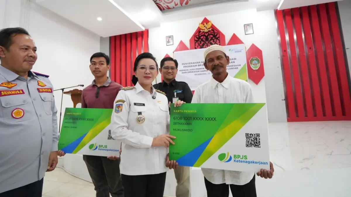 Bupati Landak, Karolin Margret Natasa, menyerahkan kartu kepesertaan BPJS Ketenagakerjaan kepada juru parkir, sopir angkutan desa, dan operator kapal secara simbolis pada, Rabu (15/4) (ISTIMEWA)